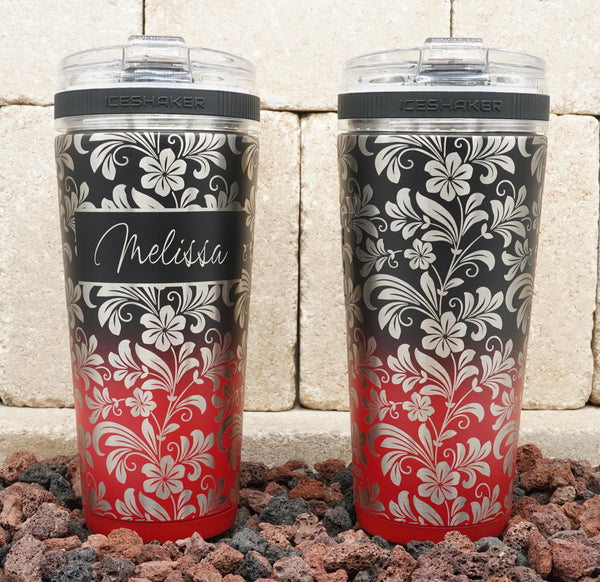 Ice Shaker Flex Bottle laser engraved with hibiscus flower pattern shown in red/black two-tone finish with firepit scene.